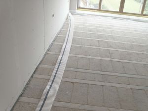 Laying the edge insulation to comply with building regulations Document L (conservation of fuel and power) Document E (sound insulation). Minimising heat loss from floor slab to wall and to isolate the floor slab and floor screed from the wall acoustically, to prevent transmission of sound.