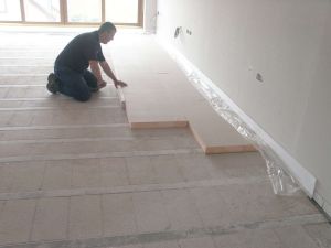 Starting to lay the floor insulation - note the staggered joints in accordance with manufacturer's recommendations.