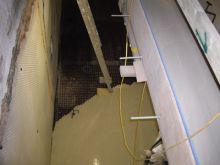 Screeding a basement through a light well using a pumped liquid screed,